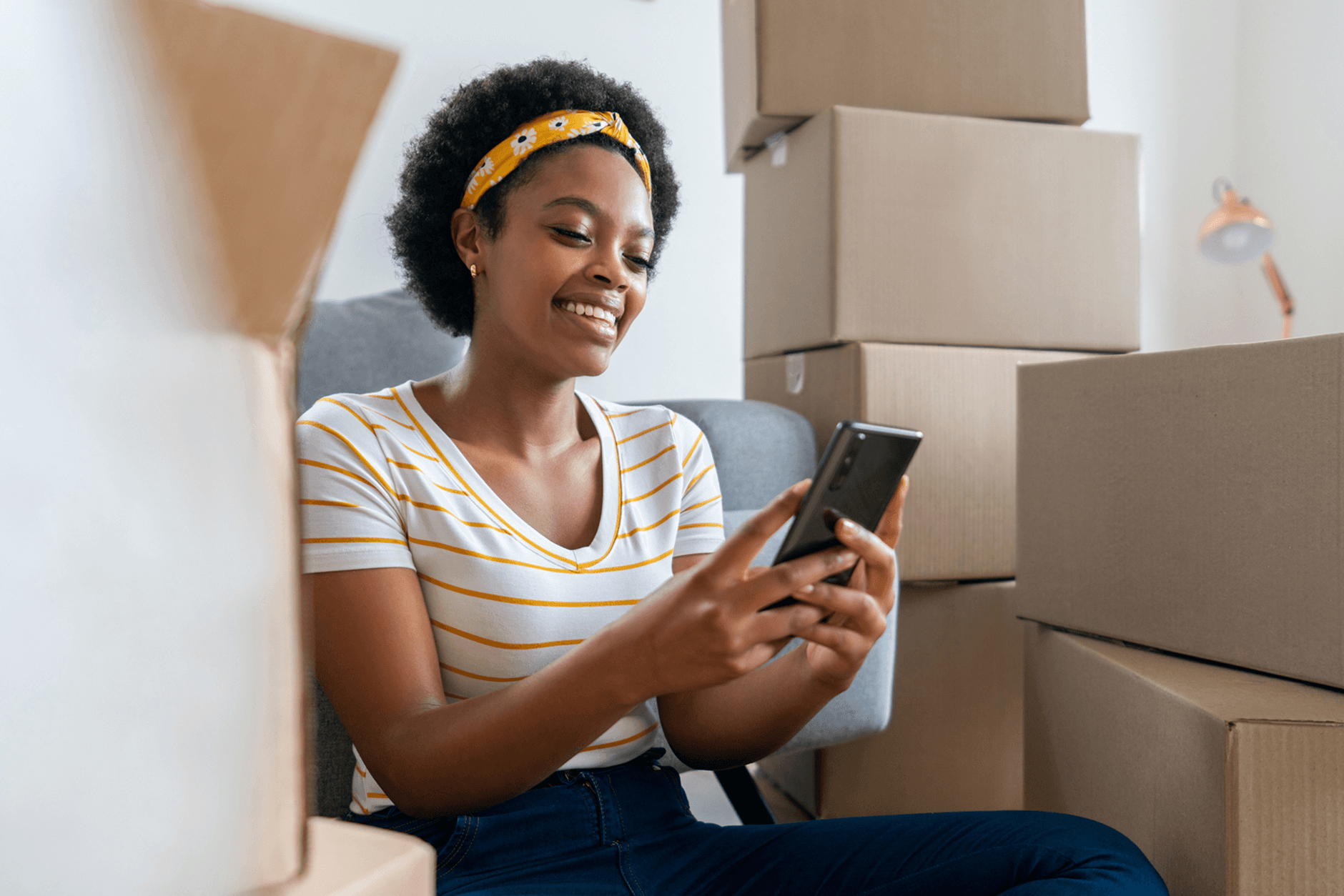 Woman with phone and moving boxes