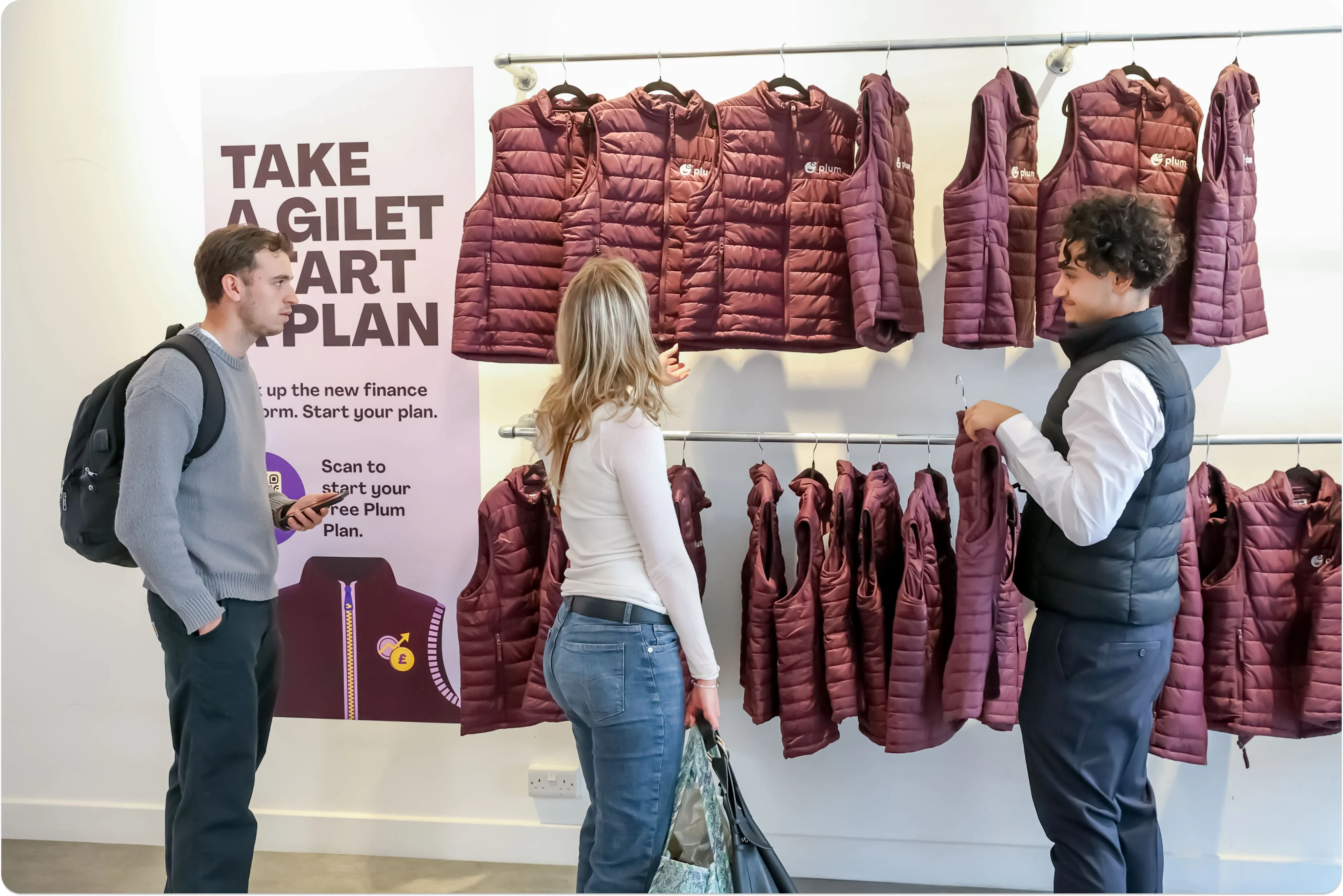 Image of 3 people looking at purple vests hanging on a rail